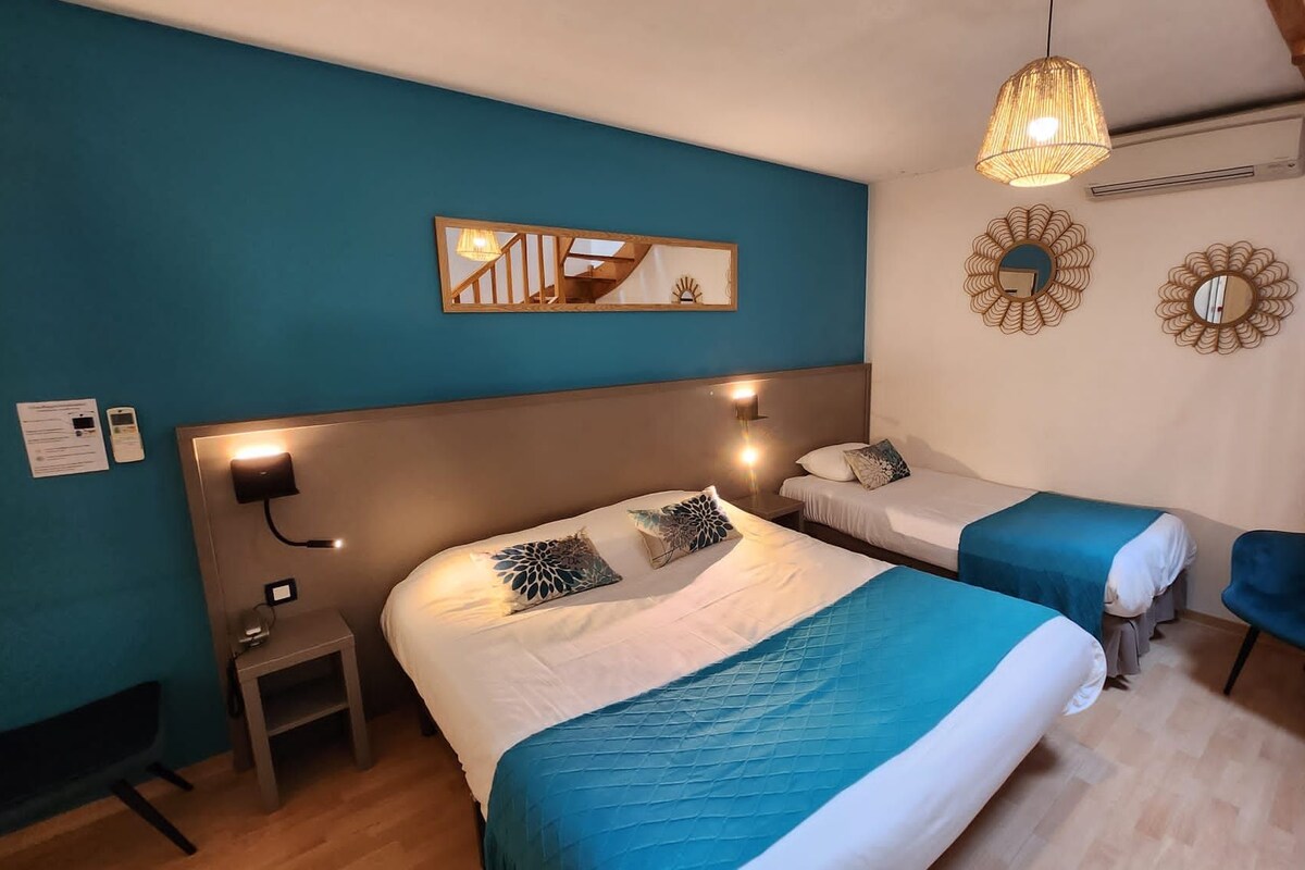 Una habitación de hotel con dos camas, un escritorio, una silla y espejos decorativos en la pared.