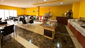 A spacious dining area with multiple tables and chairs, a buffet station, and a coffee machine. - Hostal San Marcos (San Martin de la Vega)