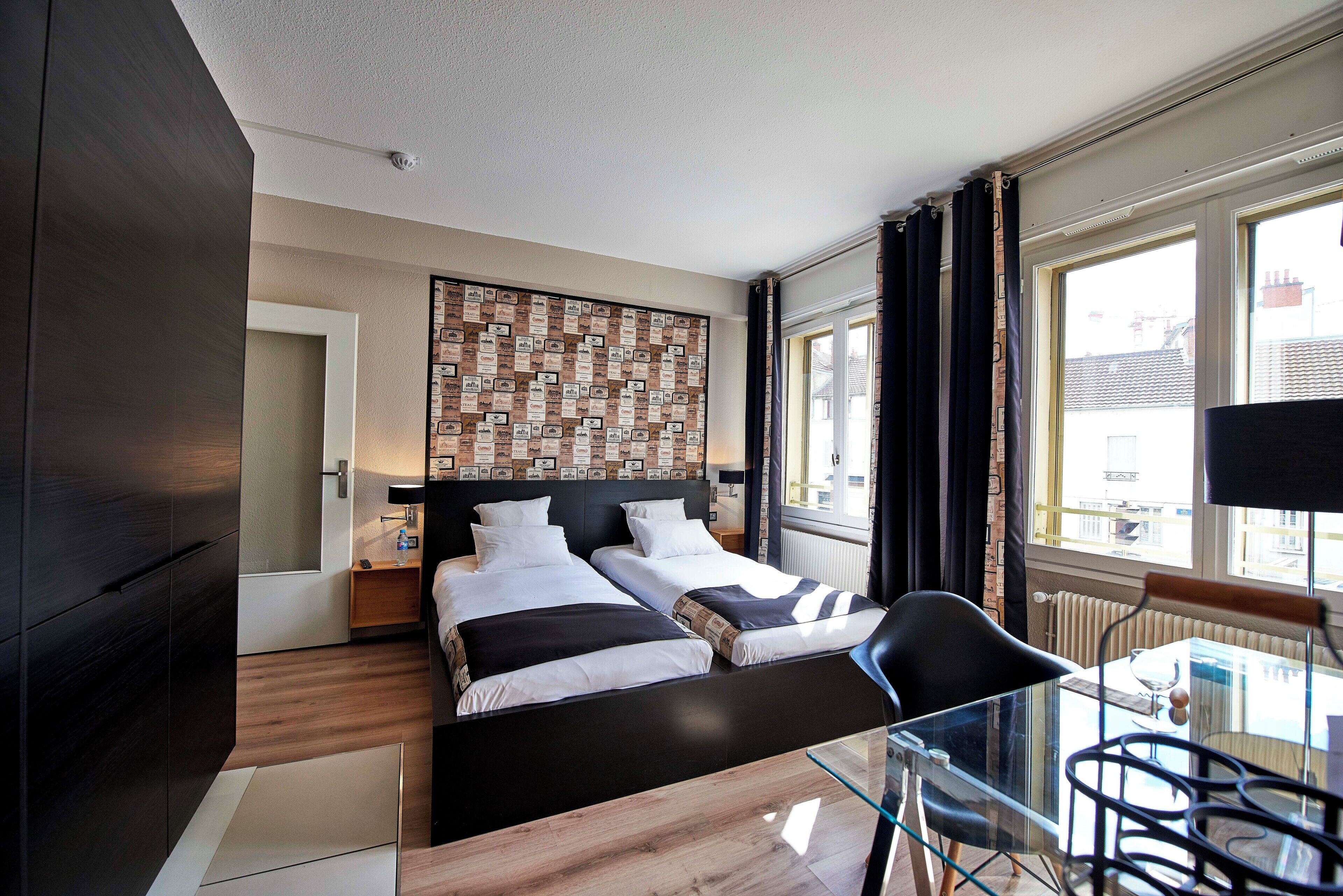 Een moderne hotelkamer met een groot bed, een glazen tafel en uitzicht op de stad.