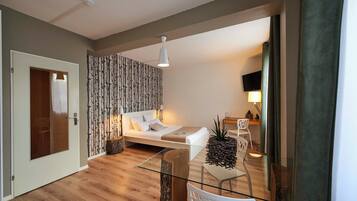 A modern bedroom with a bed, bedside table, and a glass partition.
