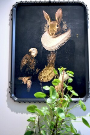 Una obra de arte enmarco con un conejo y un pájaro colgados en una pared.