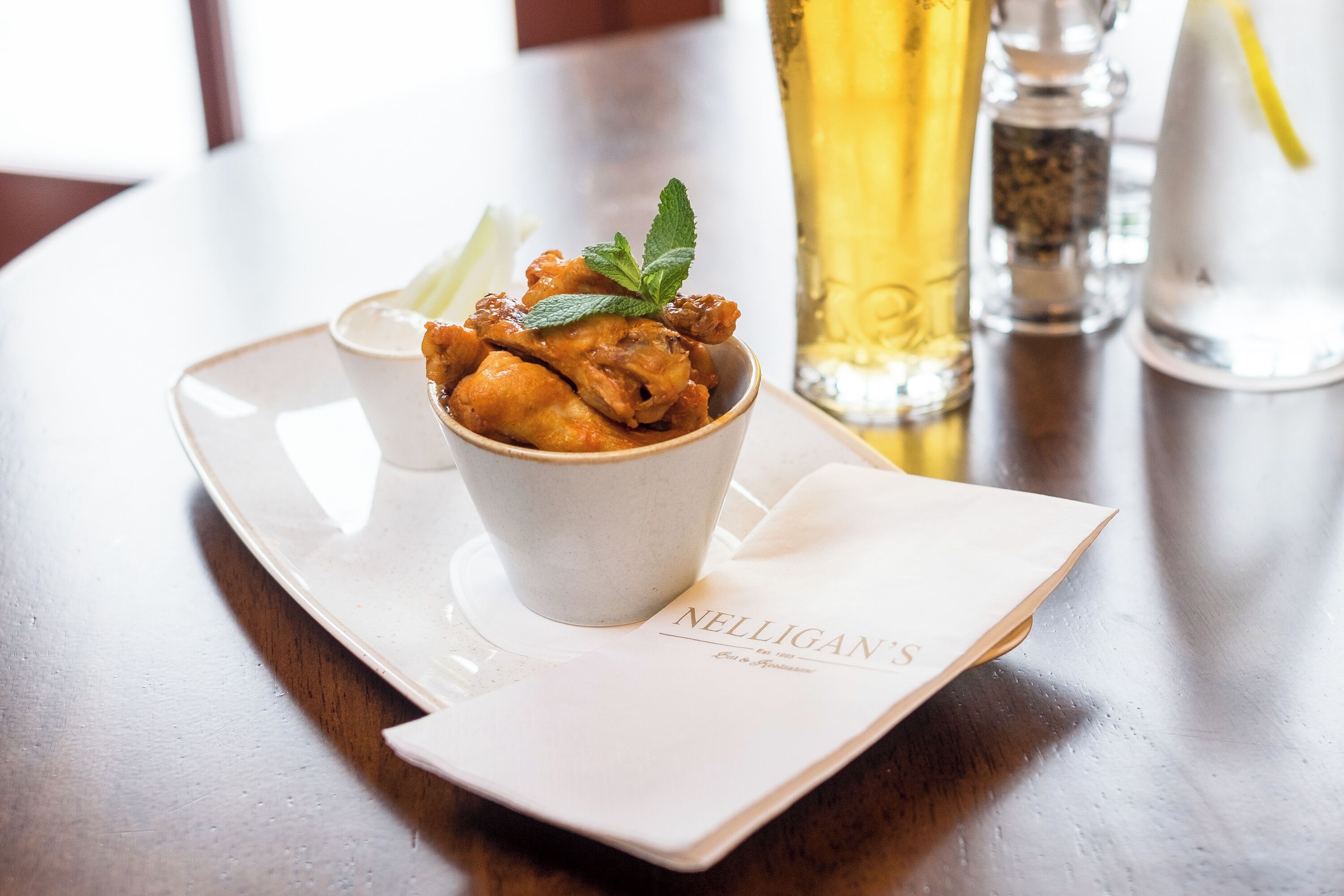 A dessert in a cup on a tray with a menu.