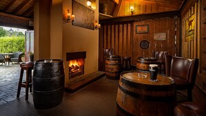 Un interior rústico con paredes de madera, una chimenea y varios barriles de madera.