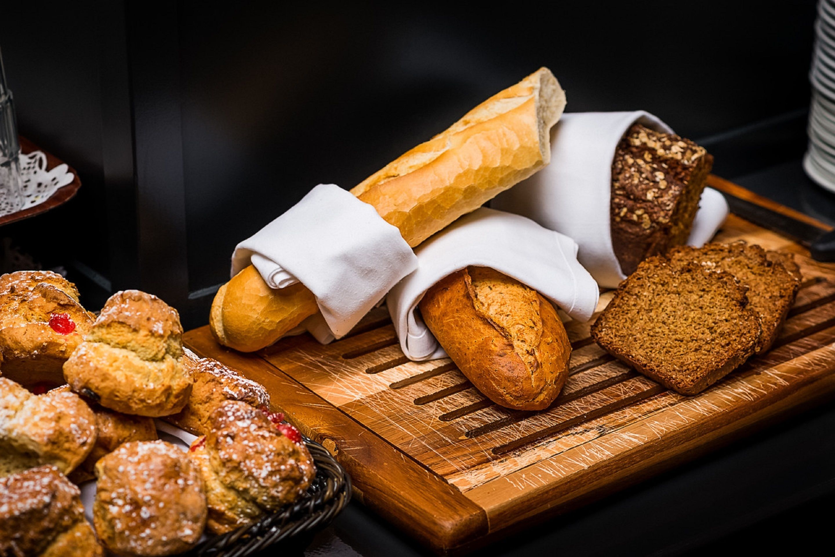 Una variedad de panes y pasteles sobre una tabla de madera.