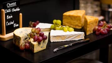 Una tabla de quesos con diferentes tipos de queso y uvas.