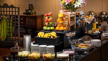 A buffet with various food items and a decorative flower arrangement.
