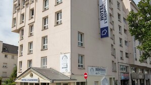 A multi-story hotel with a sign indicating "HOTEL L'EAUBONNE" and "ACCESORIUM" on the facade.