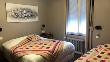 Ein Schlafzimmer mit einem großen Bett, einem Nachttisch, einer Fenster mit Jalousien und einer Wandsteckdose.