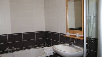 A bathroom with a bathtub, a sink, and a mirror.