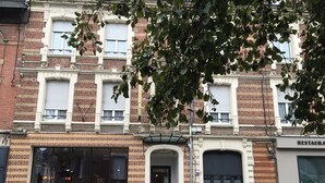 Un edificio de varios pisos con fachada de ladrillo, ventanas amplias y escaparate.