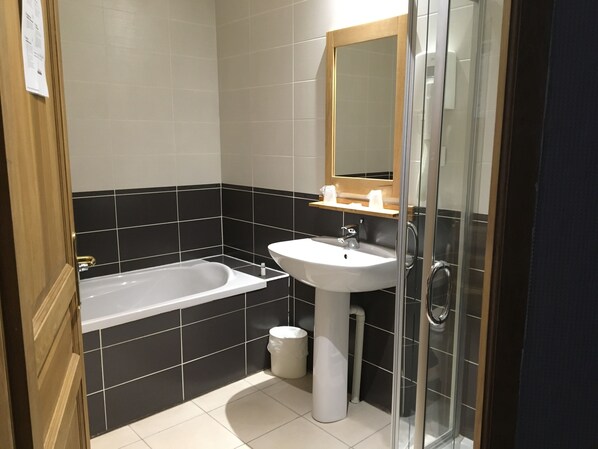 Un baño moderno con bañera, lavamanos y cabina de ducha de vidrio.