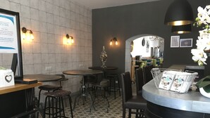 Un área de recepción con mostrador, taburetes y piso estampado.