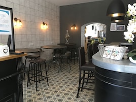 Uma área de recepção com balcão, banquetas e piso estampado.