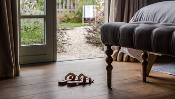 Relax in this serene room with a tufted sofa near a large window overlooking the garden.