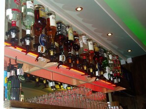 Baaritiski, jossa on useita eri alkoholijuomapulloja ja laseja.