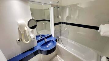 Un baño moderno con un lavamanos azul, un espejo, un cabezal de ducha de mano y una bañera.