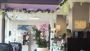 A modern interior with a reception desk, seating area, and decorative plants. - Hotel Saint Jacques (Parthenay)