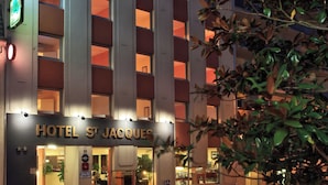A hotel with a modern facade, multiple balconies, and illuminated windows. - Hotel Saint Jacques (Parthenay)