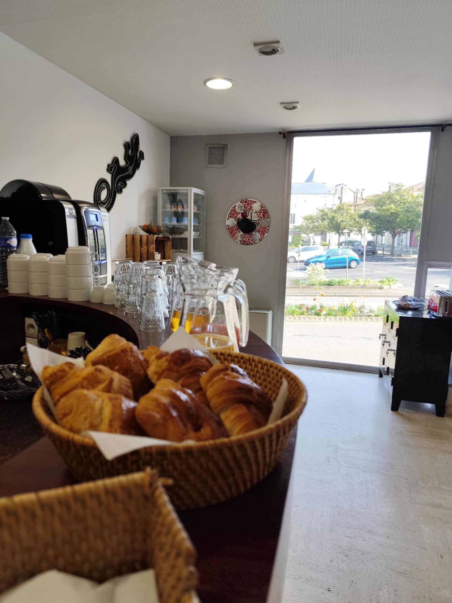 Desayuno con cruasanes, cafeteras y vista a la calle.