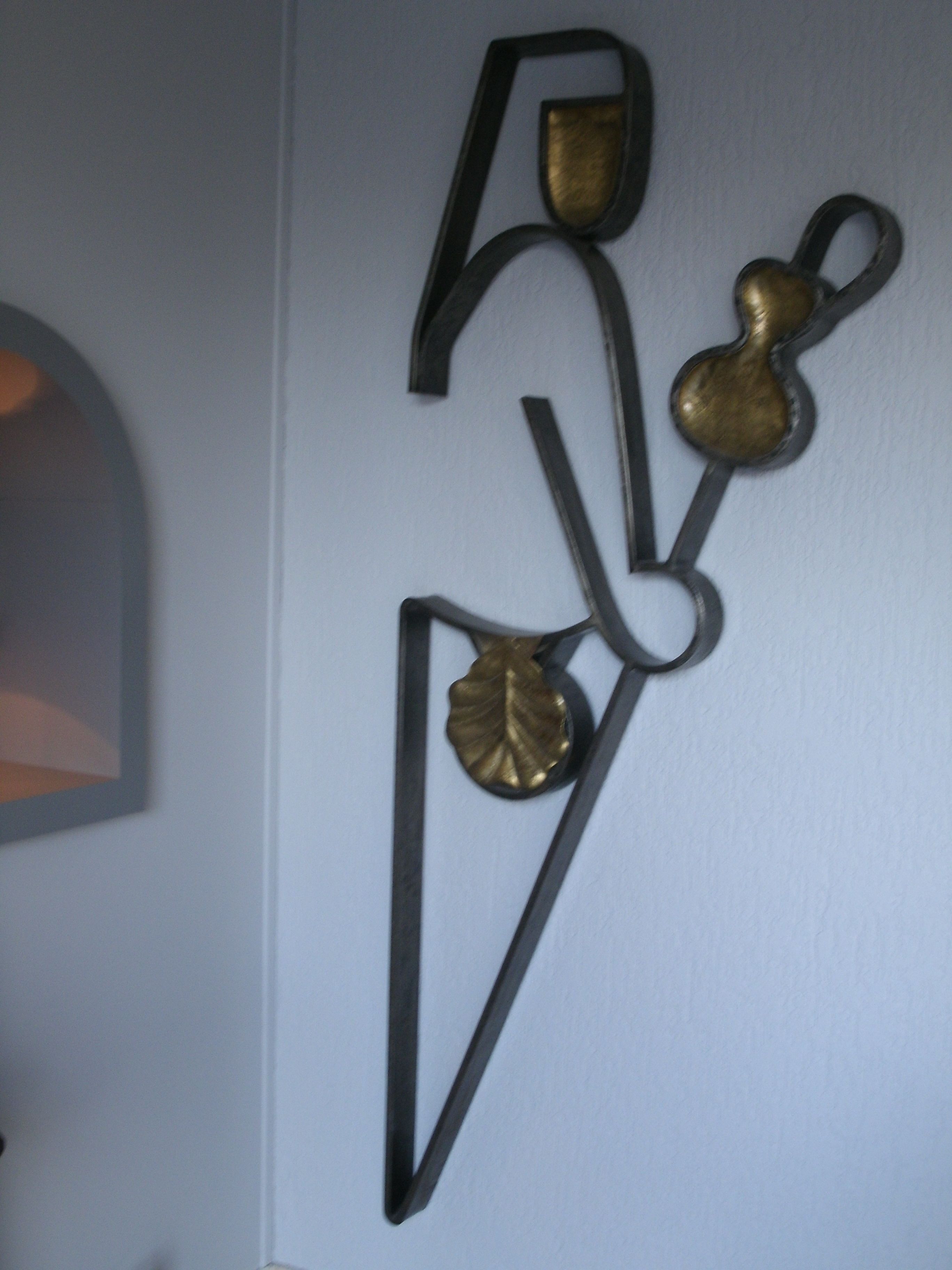 Un élément décoratif à fixer au mur, orné de motifs géométriques et de feuilles.