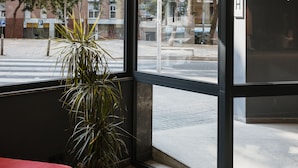 Et moderne interiør med store vinduer, en rød sofa og hængende pendellamper.