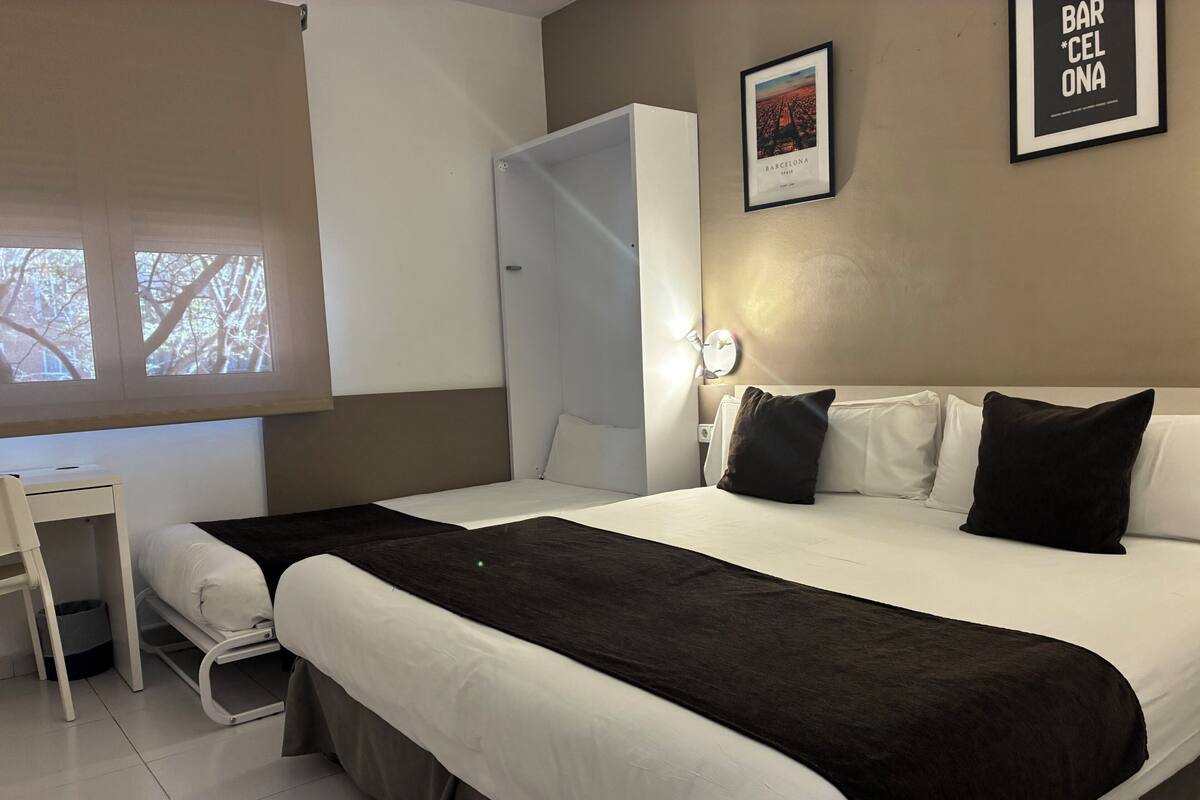 Una habitación de hotel con cama, mesita de noche y armario.