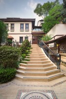 A staircase leading to a building with multiple windows and a balcony.