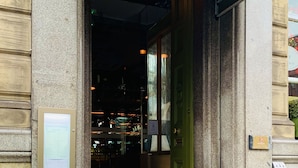 Indgangen til The Sir T hotel med en grøn markise og et skilt over døren.