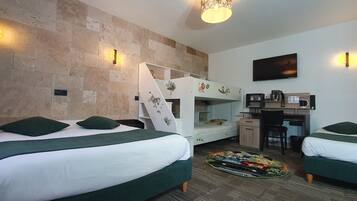 A hotel room with bunk beds, a desk with a chair, a flat-screen TV, and a coffee machine.