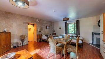 Studio avec Jacuzzi | Living area | 25-inch flat-screen TV with digital channels