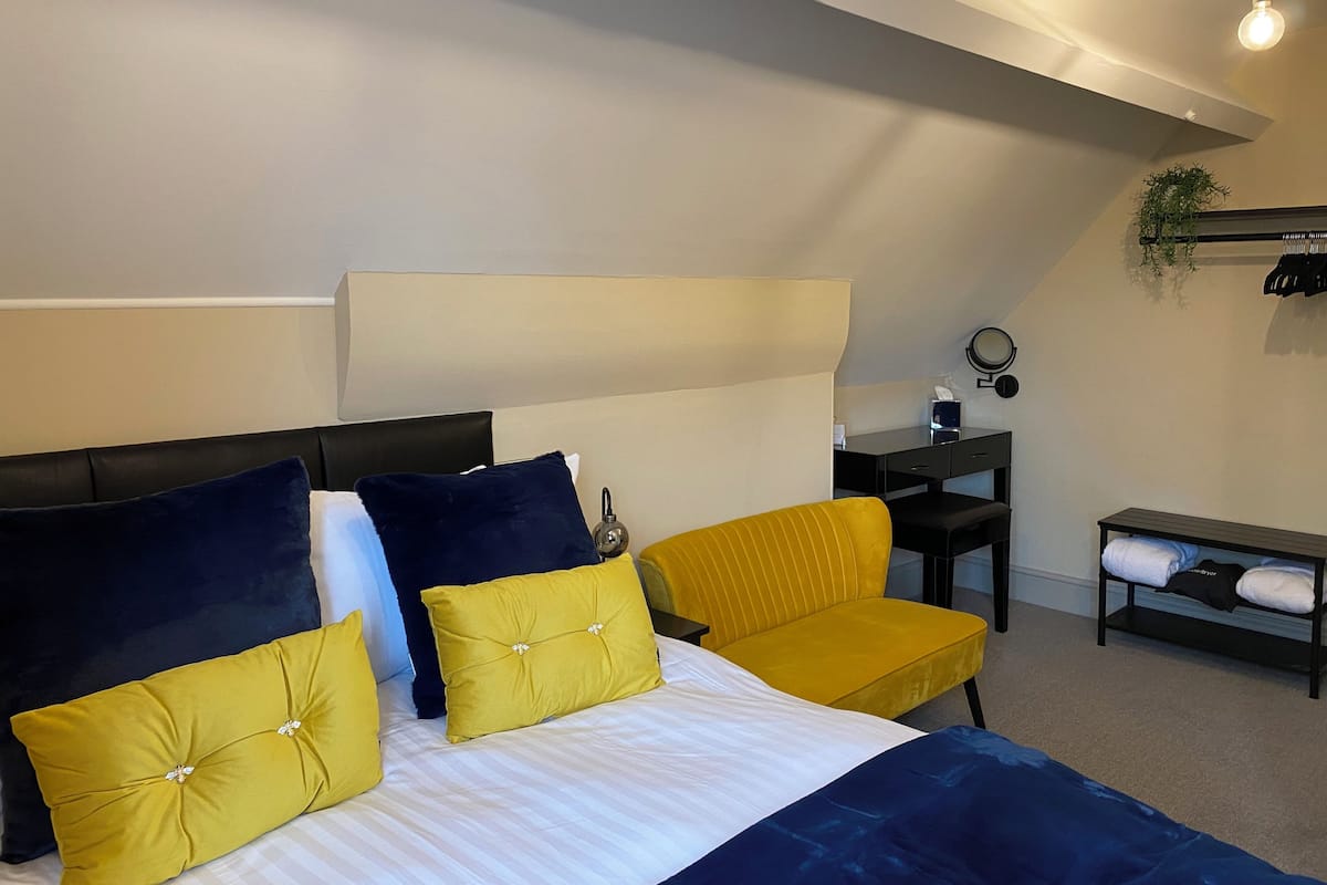 Un dormitorio moderno con una cama, un escritorio y una silla.