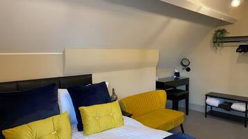 A modern bedroom with a bed, a desk, and a chair.