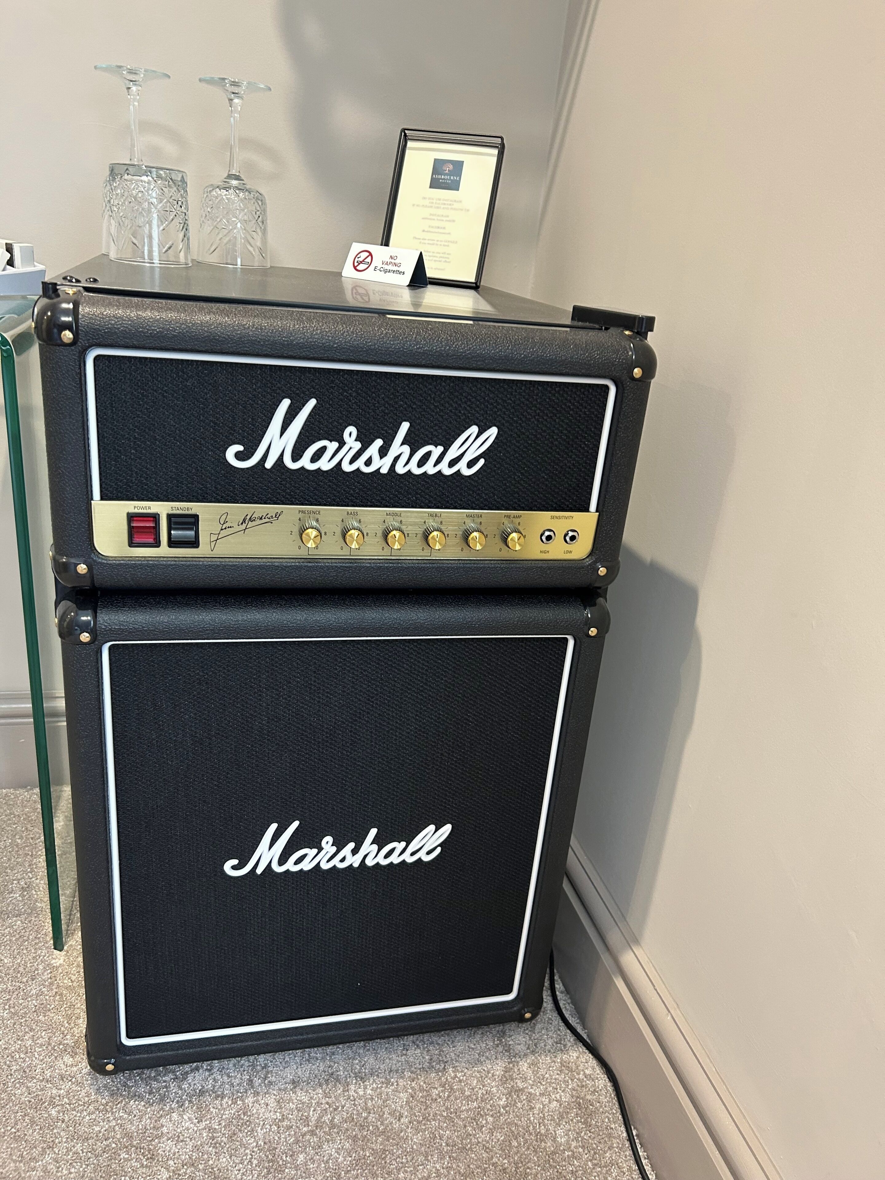 Un amplificador Marshall con un soporte y un cartel que prohíbe fumar.