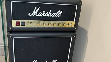 Un amplificador Marshall con un soporte y un cartel que prohíbe fumar.