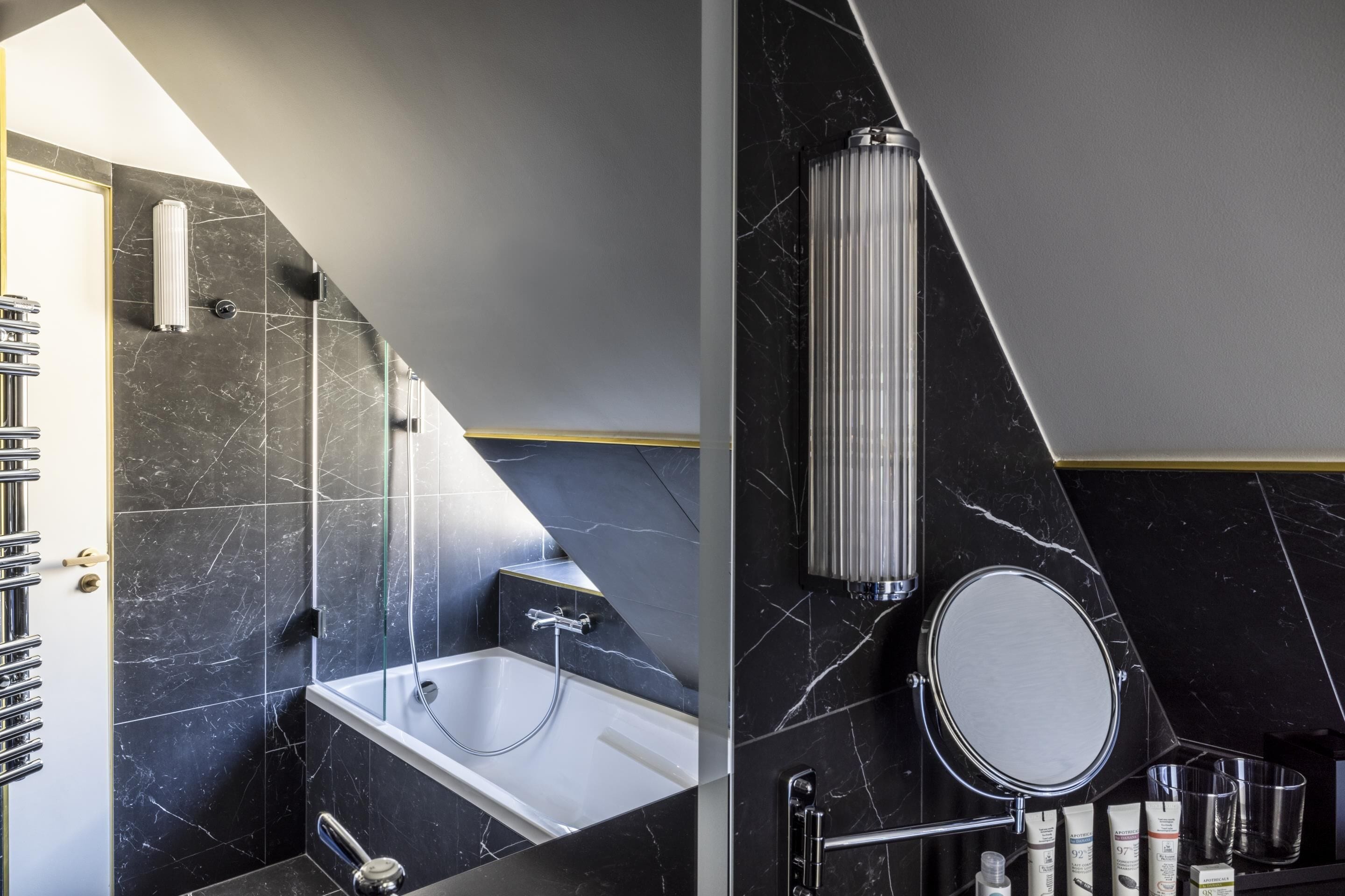 Un baño moderno con bañera, ducha y un espejo grande.
