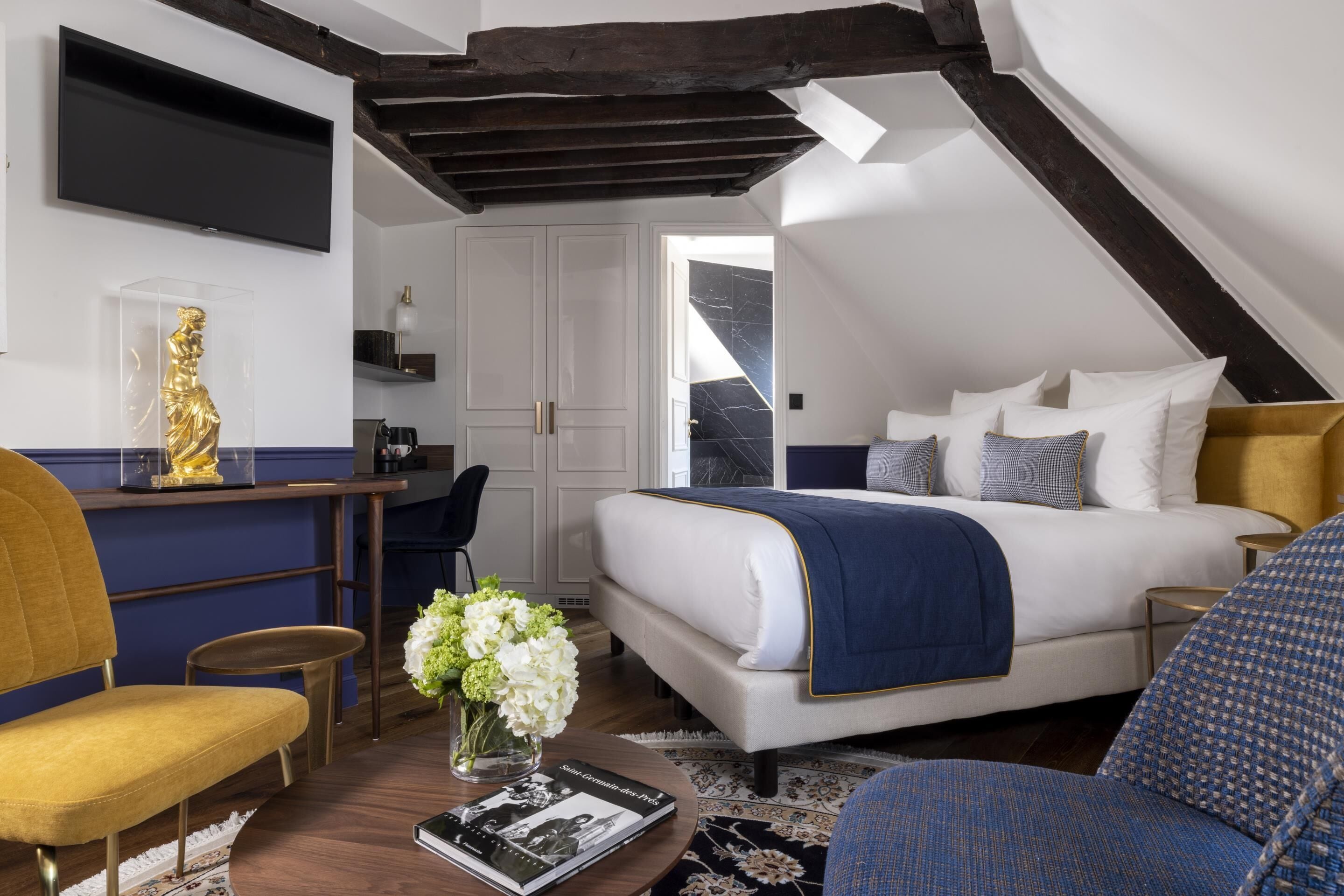 Un dormitorio moderno con cama, mesitas de noche, un escritorio y una silla.