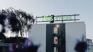 A building with a sign reading "ibis styles" and a visible entrance. - ibis Styles Nancy Laxou (Laxou)