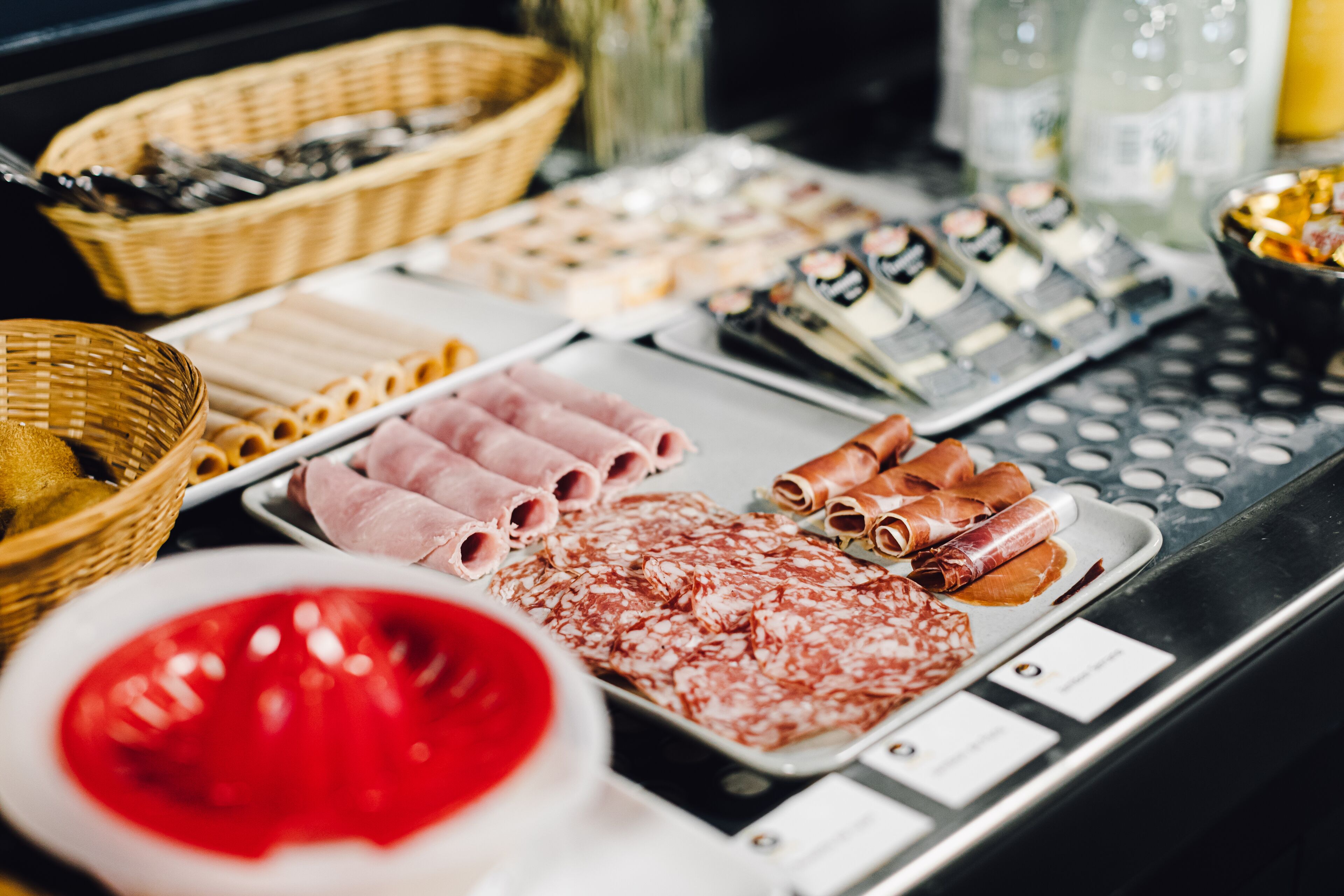 A variety of food items including meats, cheeses, and pastries on a buffet table.