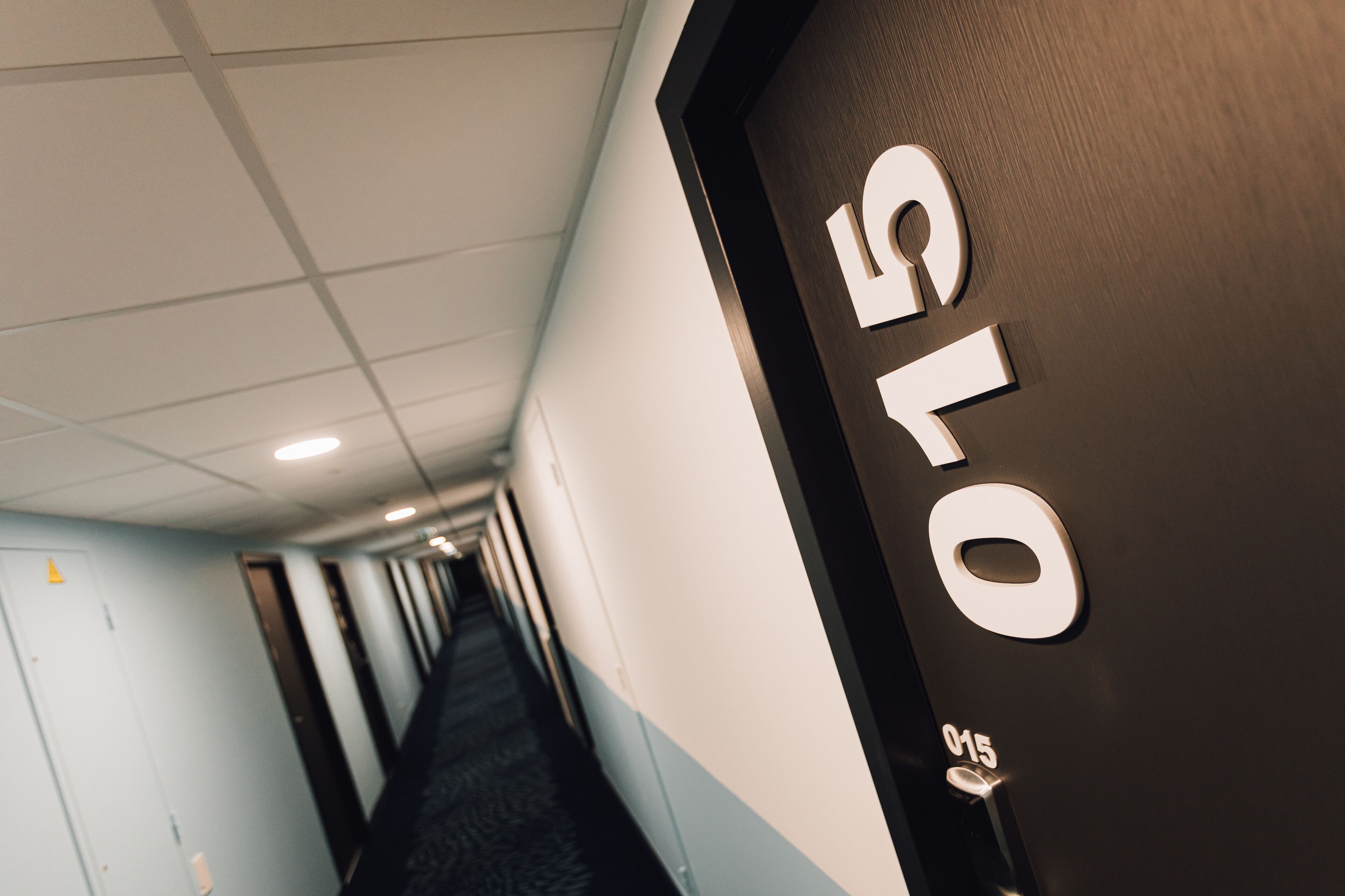 A hallway with a door labeled "1010" and a number "015" on the door handle.