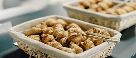 Two wicker baskets filled with croissants on a table.