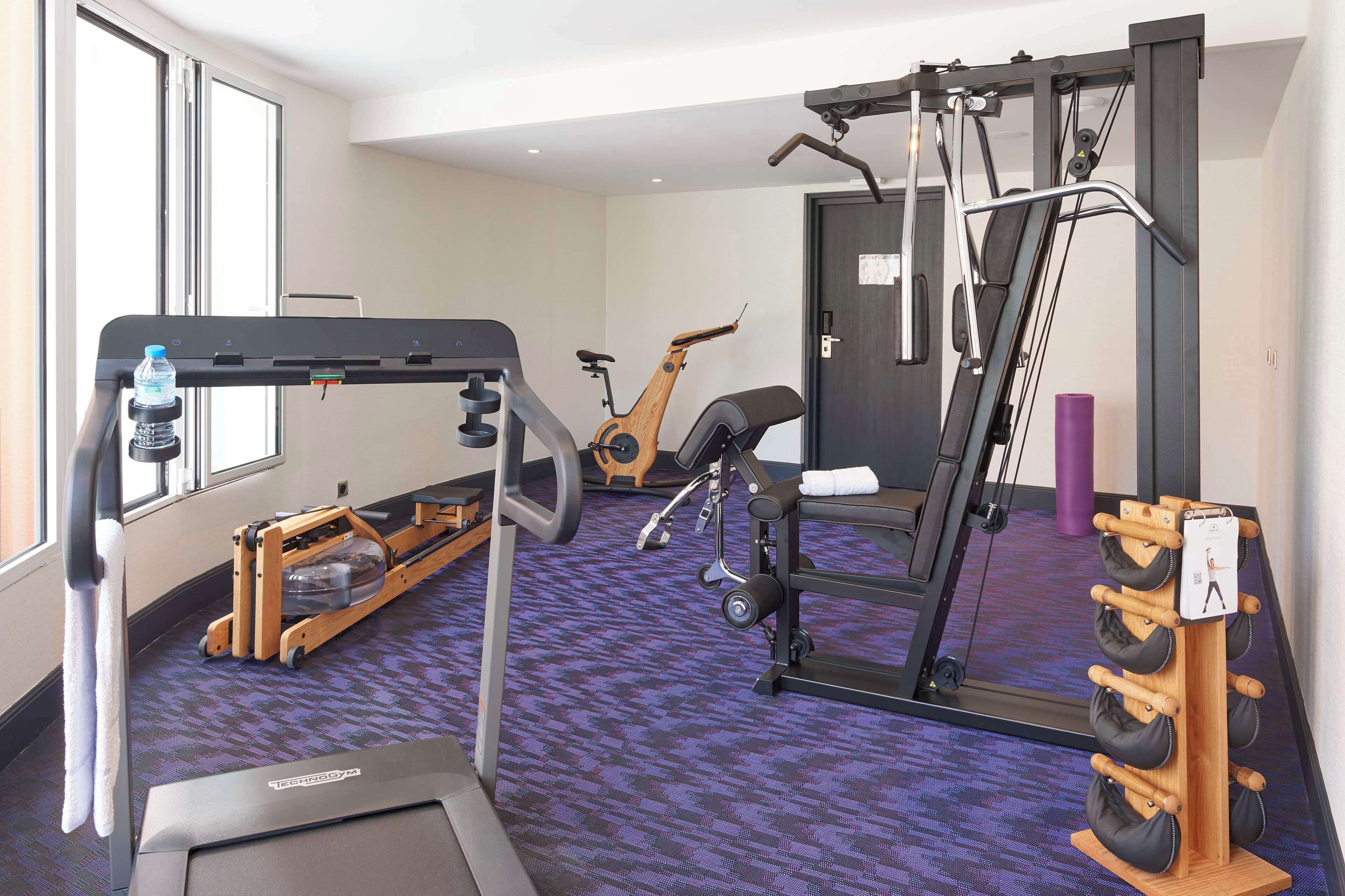A gym with a treadmill, exercise bike, and weight machines.