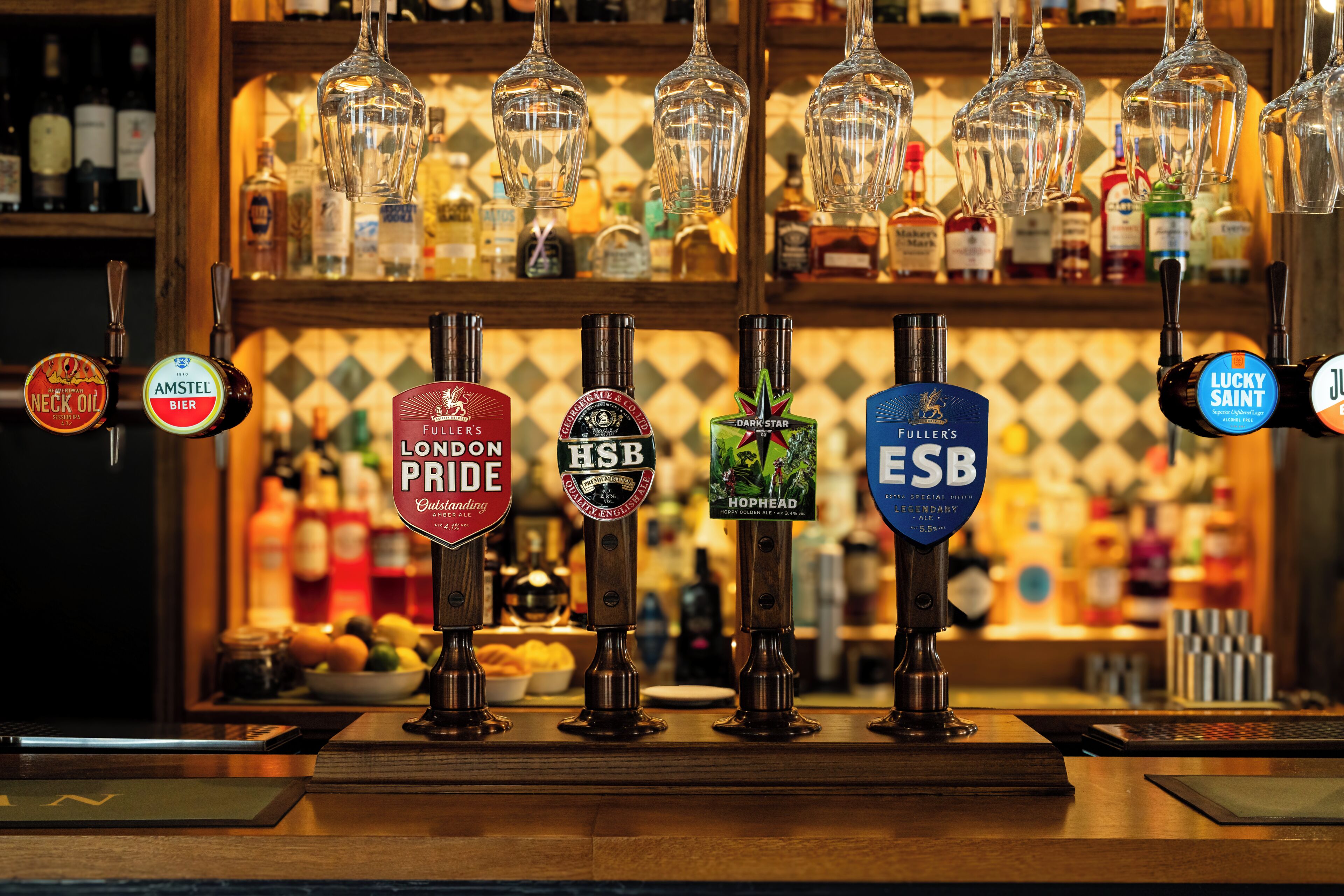 A bar with multiple beer taps and a variety of bottles in the background.