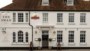 A white building with 'The Swan' and 'Fuller's' signs, indicating a pub with dining, bedrooms, and private events. - The Swan (Arundel)