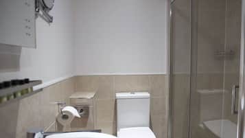 A modern bathroom with a glass shower enclosure, a white sink, and a toilet.