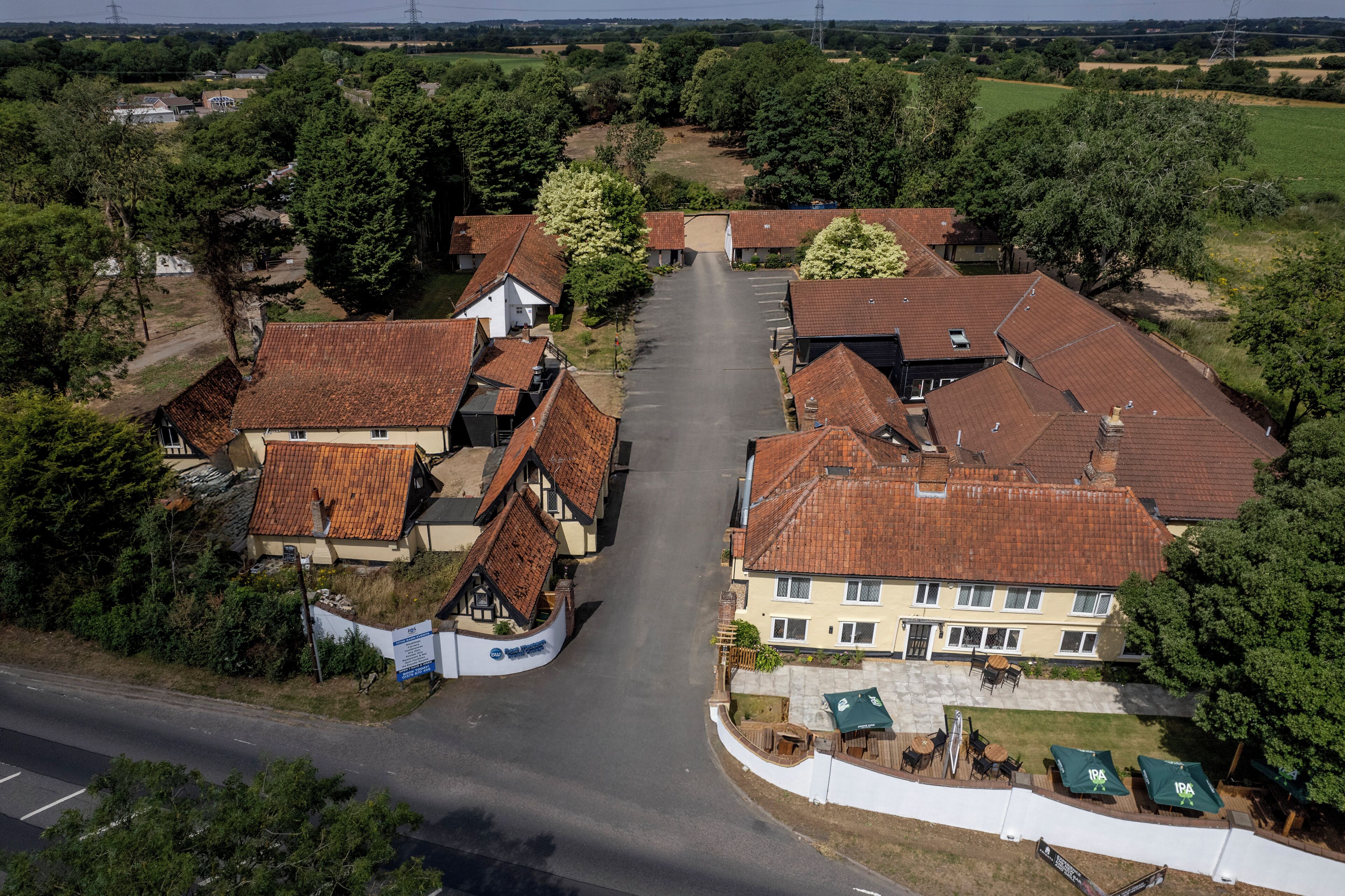 A village with traditional houses, a central road, and a parking area.