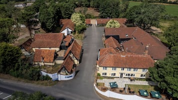 A village with traditional houses, a central road, and a parking area.