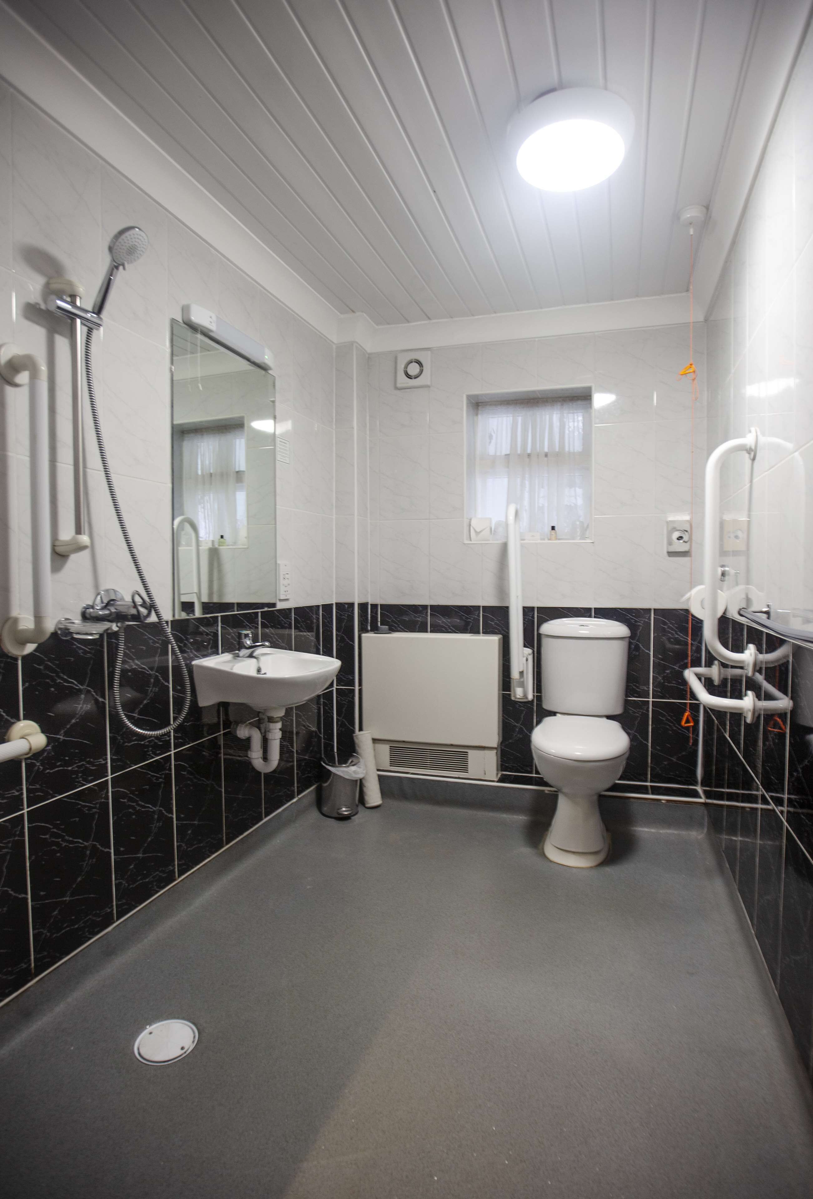 Un baño moderno con lavamanos, inodoro y ducha blancos.