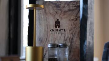 A wooden sign with a logo and text for 'Knights Bar & Grill'.
