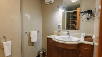 A modern bathroom with a large sink, wooden vanity, and a mirror.