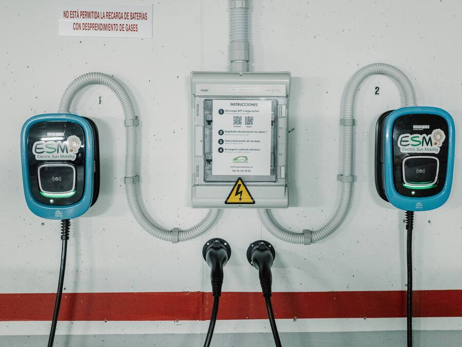Two electric vehicle charging stations with cables connected to a central power box.